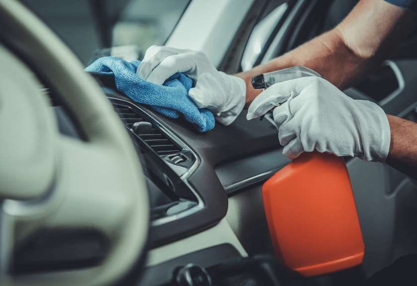 man cleaning car interior dashboard